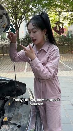 a woman is fixing the hood of a car