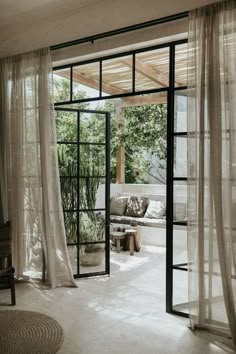 an open door leading into a living room with sheer curtains