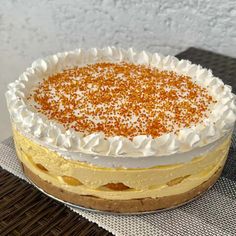 a cake with white frosting and orange sprinkles sitting on a table