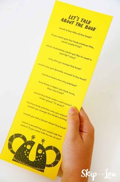 someone holding up a yellow bookmark with the words let's talk about the book