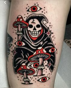 a person with a skull and mushroom tattoo on their leg