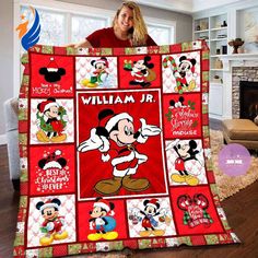 a woman holding up a mickey mouse quilt