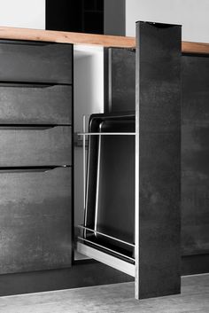 an open cabinet door in a kitchen next to a counter top with drawers on each side