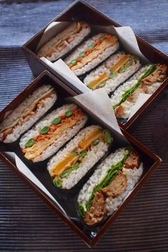 several trays filled with sandwiches on top of a wooden table next to each other