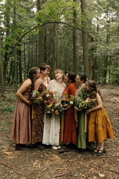 a group of women standing next to each other in the woods