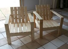 two wooden chairs sitting on top of a tiled floor