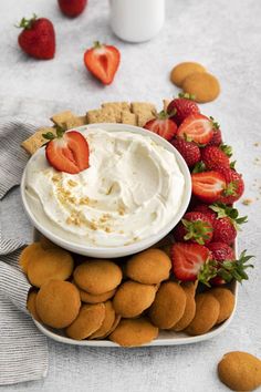 a platter with strawberries, crackers and whipped cream