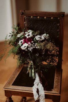 a bouquet of flowers sitting on top of a wooden table next to an old suitcase