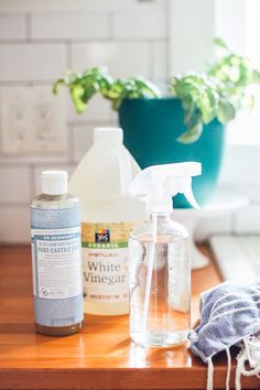 bottles of cleaning products sitting on top of a wooden table