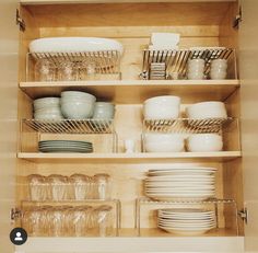 dishes and glasses are stacked on the shelves in this kitchen cabinet with no doors or drawers