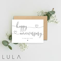 a card with the words happy anniversary written in cursive writing on it and flowers