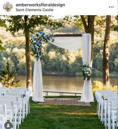 an outdoor ceremony setup with white chairs and blue flowers on the aisle, overlooking a lake