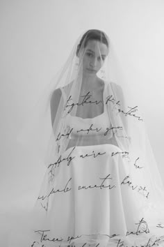 a woman in a wedding dress with writing on the veil and back of her head