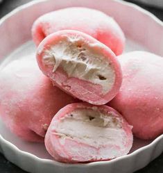 some pink donuts are in a white bowl