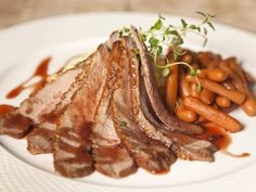 a white plate topped with meat and carrots