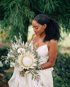 a woman in a white dress holding a bouquet