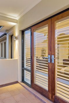 an open door leading to a balcony with sliding glass doors and blinds on the outside