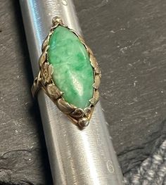 "Lovely hand wrought genuine green Jade Ring-Stamped 14K-Arts and Crafts-Art Nouveau from the early 1900s.  Condition is very good any slight wear commensurate with age-photos show the details.  small size  4 1/3, wt.- 5.3 grams, approx 1\" north to south on finger.  The ring was made by hand with a floral setting, the navette cabochon Jade is approx. 22mm by 9mm.  Truly an enchanting creation." Vintage Marquise Jewelry For Gifts, Antique Oval Emerald Ring For Anniversary, Antique Oval Emerald Ring Stamped 14k, Oval Engraved Green Emerald Ring, Vintage Oval Emerald Diamond Ring, Vintage May Birthstone Rings, Antique Emerald Ring As Gift, Engraved Oval Green Emerald Ring, Vintage Emerald Jewelry Collectible