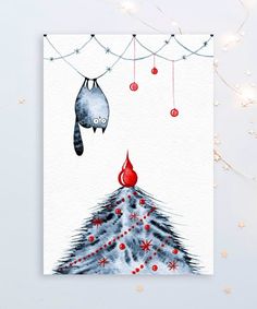 a christmas card with a cat hanging from the top of a tree and an ornament above it