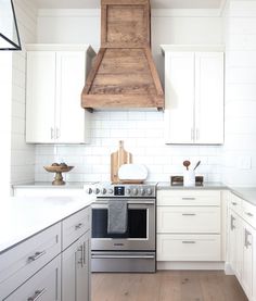 a stove top oven sitting inside of a kitchen next to white cabinets and counter tops