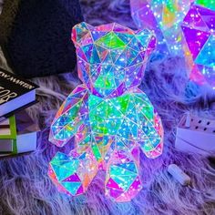 a teddy bear sitting on top of a fur covered floor next to books and other items