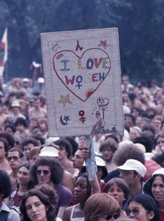 a group of people holding up a sign that says i love women