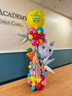 a bunch of balloons that are in the shape of animals on a pole with an animal balloon attached to it