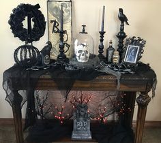 a mantle with candles, skulls and decorations on it in front of a white wall