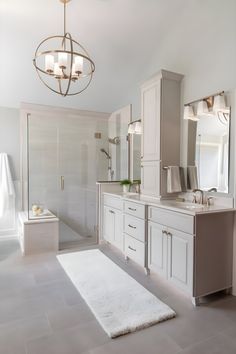 a large bathroom with two sinks and a bathtub next to a walk in shower