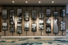 a wall with many black and white pictures hanging on it's sides in an office