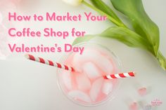 a cup filled with pink and white candy canes next to tulips on top of a table