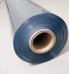 a roll of blue plastic film sitting on top of a white table next to a pipe