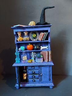 a blue book shelf filled with lots of books and other things on top of it