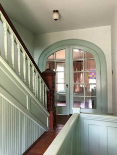 an entry way leading up to a door with glass panes on the side and wood floors