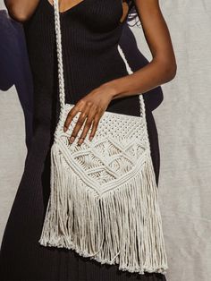 Female model wearing macramé purse in black dress crossbody. Cream Crochet Crossbody Bag With Braided Handles, Summer Macrame Crossbody Bag, Bohemian Beige Bag With Fringe, Summer Crossbody Macrame Bag, Cream Bohemian Shoulder Bag For Vacation, Bohemian Cream Shoulder Bag For Vacation, Beige Macrame Shoulder Bag, Bohemian Beige Crossbody Shoulder Bag, Chic Handwoven Crochet Crossbody Bag