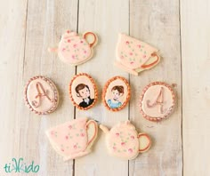 decorated cookies with teapots and cupcakes are arranged on a wooden table