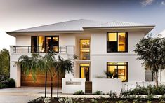 a white two story house with lots of windows and palm trees in the front yard