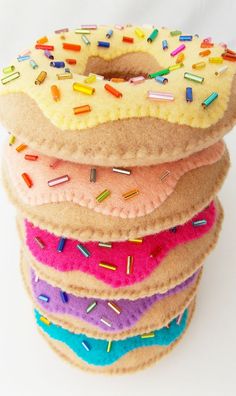 a stack of doughnuts with sprinkles on them sitting next to each other