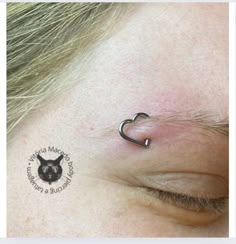 a close up of a person's nose with a small heart tattoo on it