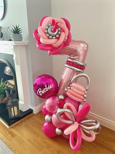 a pink and silver vase with balloons attached to it on top of a wooden floor