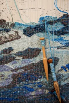 a close up of a piece of fabric with a wooden stick and thread on it