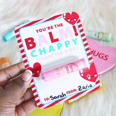 someone is holding an empty lip balm in front of some valentine's day items