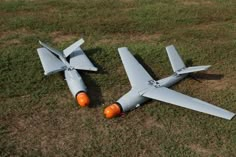 two model airplanes sitting on top of a grass covered field