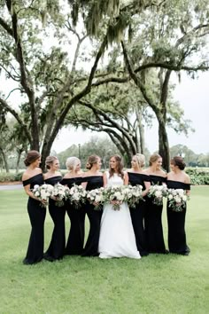 a group of women standing next to each other on top of a lush green field