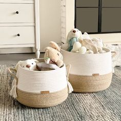 two baskets with stuffed animals in them sitting on the floor next to a white dresser