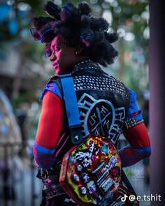 a woman with dreadlocks carrying a colorful backpack