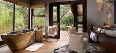 a bathroom with a large tub in the middle of it's floor to ceiling windows