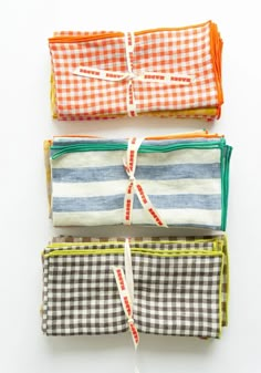 four different colored napkins tied together on a white surface