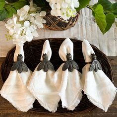 four napkins with black and white designs on them sitting in a wicker basket