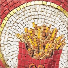 an artistic mosaic design on the side of a building with yellow and red bricks in it